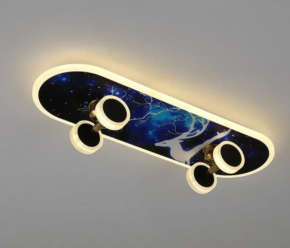 Plafonnier LED skateboard Dalumea, modèle Cerf galaxie : planche bleu nuit étoilée à motif de cerf blanc, contour lumineux et quatre roues éclairantes